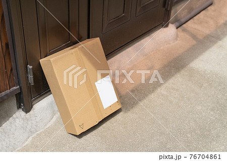 一戸建ての玄関に届いた商品のダンボール　（置き配） 76704861