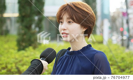 街頭インタビューを受ける女性 76704977