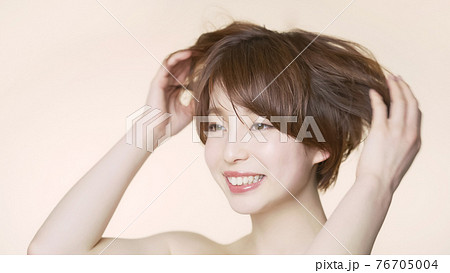 髪をくしゃくしゃにするショートヘアの女性 ヘアケアイメージ の写真素材