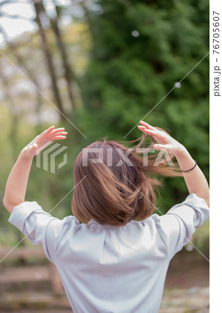 サラサラ髪を手でかき上げる若い女性の写真素材