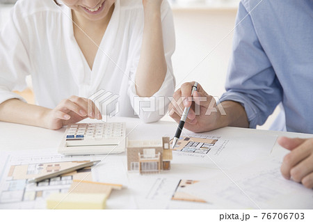 マイホーム購入を相談する若い夫婦の手元 マイホーム購入を相談する若い夫婦の手元 76706703