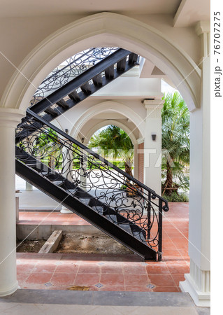 Classic black iron staircase in a vintage style for walking up and down a European style building. 76707275