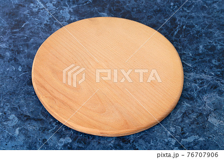 A cutting board is on a blue marble countertop. 76707906