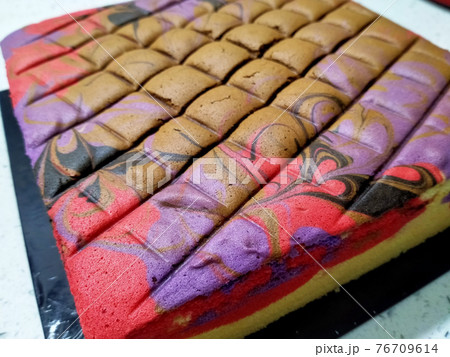 Sponge cake with colourful random patterns. Placed on a white table. Simple cake as a dessert. 76709614