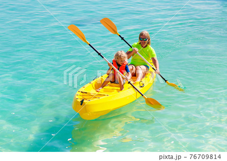 Kids kayaking in ocean. Family in kayak in tropical sea Kids kayaking in ocean. Family in kayak in tropical sea 76709814
