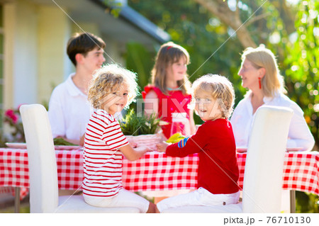 Family eating outdoor. Garden summer fun. 76710130