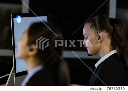 Caucasian young woman working overtime late at night in call center office Caucasian young woman working overtime late at night in call center office 76710530