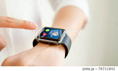 Woman hand touching on smartwatch to unlock and show call screen with friend. 76711842