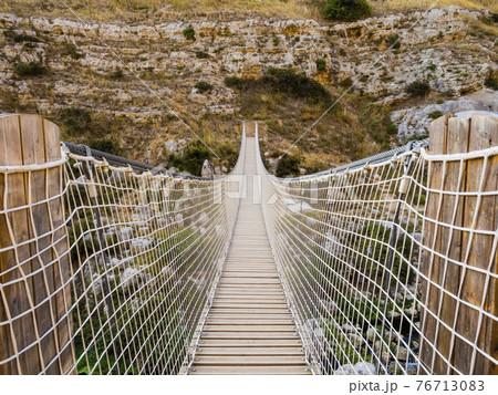Impressive hanging bridge over Gravina canyon in Murgia National Park, Matera, Italy 76713083