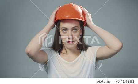 Photo of woman wearing orange helmet on grey 76714281