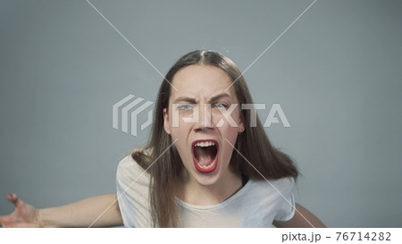 Photo of young yelling girl on grey Photo of young yelling girl on grey 76714282