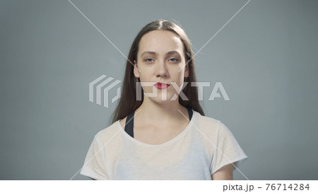 Photo of young impudent girl on grey Photo of young impudent girl on grey 76714284