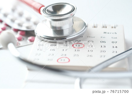 medical pills and stethoscope on calendar on white background  76715700
