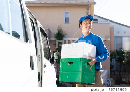 荷物を運ぶ配送スタッフ 76715996