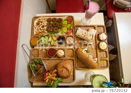 A lot of fast foods, burger, hamburger, hotdog, fried chicken, sauce, cocktail on the table A lot of fast foods, burger, hamburger, hotdog, fried chicken, sauce, cocktail on the table 76720132