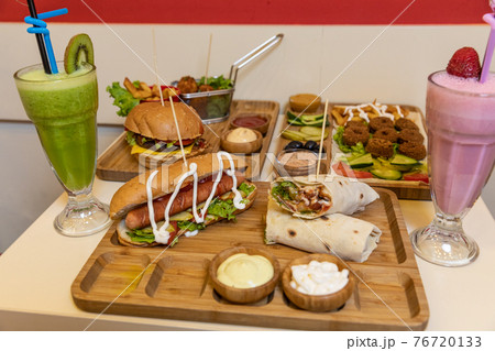 A lot of fast foods, burger, hamburger, hotdog, fried chicken, sauce, cocktail on the table A lot of fast foods, burger, hamburger, hotdog, fried chicken, sauce, cocktail on the table 76720133
