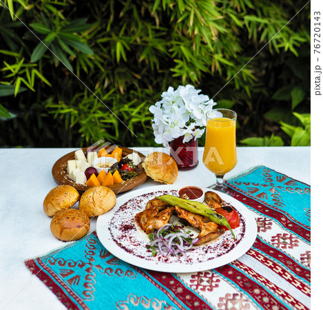 Tasty chicken meat meal with ketchup, bread, juice with green background 76720143