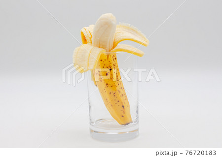 バナナジュースイメージ　むいたバナナがコップに入っている 76720183