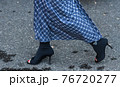 Detail of a fashionable outfit woman wearing black shoes and blue plaid long skirt 76720277