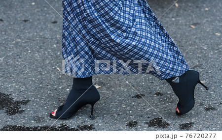 Detail of a fashionable outfit woman wearing black shoes and blue plaid long skirt Detail of a fashionable outfit woman wearing black shoes and blue plaid long skirt 76720277