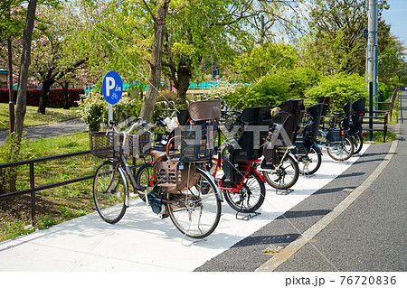 公園の駐輪場に並んだ子供乗せ電動自転車 公園の駐輪場に並んだ子供乗せ電動自転車 76720836