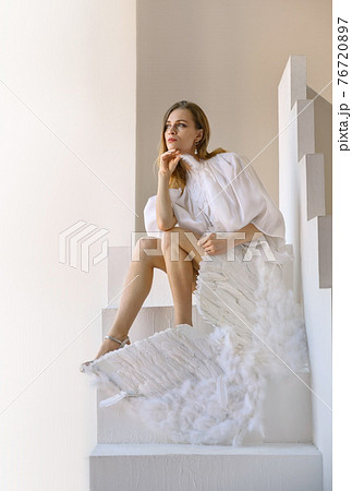 Attractive woman with angel wings posing in the studio 76720897