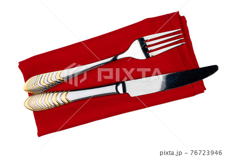 Set of cutlery on red cloth napkin on white background Set of cutlery on red cloth napkin on white background 76723946