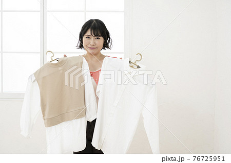 どの服にしようか選ぶ女性 どの服にしようか選ぶ女性 76725951
