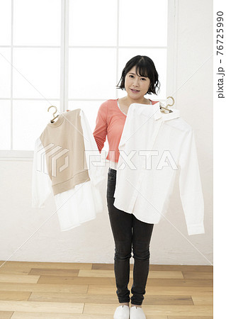 どっちの服にしようか悩む若い女性 どっちの服にしようか悩む若い女性 76725990