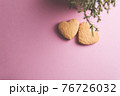 Two cookies in shape of a heart next to each other on a pink background. The concept of Valentine's Day. 76726032