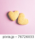 Two cookies in shape of a heart next to each other on a pink background. The concept of Valentine's Day. 76726033