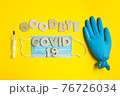Words GOODBYE COVID 19 from wooden letters and syringe, inflated medical glove and facemask. vaccine and the end of epidemic concept. 76726034
