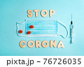 Words STOP CORONA from wooden letters, syringe and facemask. Vaccination and the end of epidemic concept. 76726035