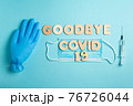 Words GOODBYE COVID 19 and syringe, inflated medical glove and facemask. vaccine and the end of epidemic concept. 76726044