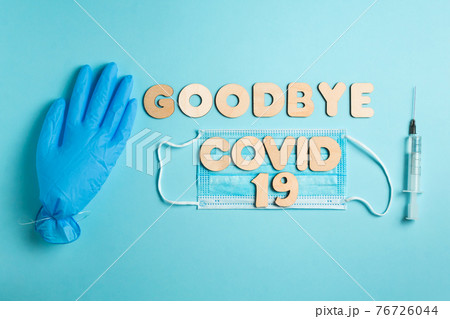 Words GOODBYE COVID 19 and syringe, inflated medical glove and facemask. vaccine and the end of epidemic concept. 76726044