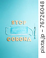 Words STOP CORONA from wooden letters, syringe and facemask. Vaccination and the end of epidemic concept. 76726048