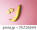 Two cookies in shape of a heart next to each other and banana on a pink background. The concept of Valentine's Day. 76726049