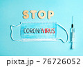 Words STOP CORONAVIRUS from wooden letters and letters on facemask and syringe. Vaccination and the end of epidemic concept. 76726052