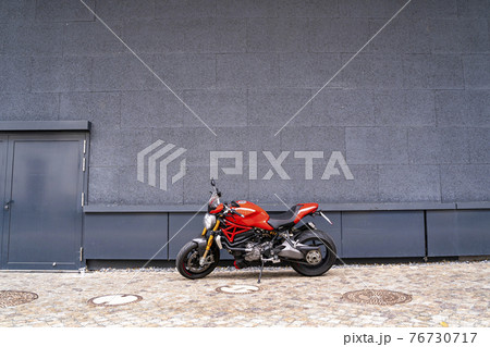 Sporty racing powerful stylish modern red motorcycle stands parked on the road 76730717