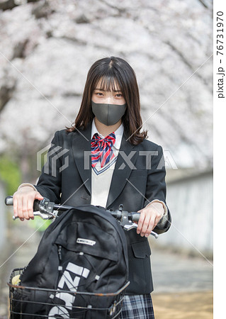 満開の桜の中、通学する女子高生 76731970