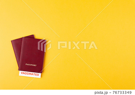 Passports with vaccinated stamp on blank on yellow background Passports with vaccinated stamp on blank on yellow background 76733349