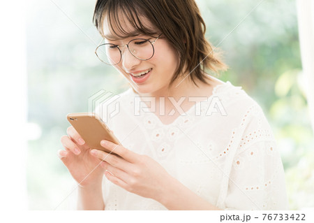 スマートフォンを見る若い女性 スマートフォンを見る若い女性 76733422