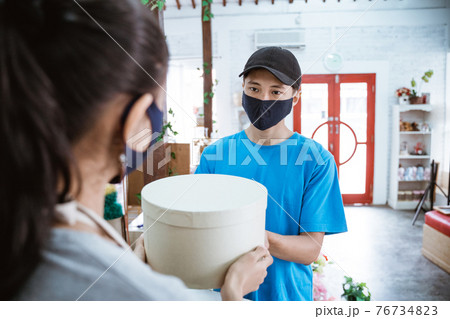 portrait smiling young female shopkeeper receiving a package portrait smiling young female shopkeeper receiving a package 76734823