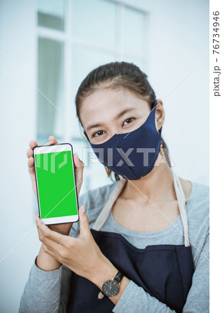 close up florist woman shopkeeper holding phone showing qris barcode 76734946