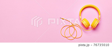 Yellow headphones on pink banner. Minimal Music concept, flat lay, copy space 76735010