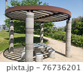 春の昼下がり。あおぞらと陽だまりの公園にある休憩所。初夏を思わせる人気のない公園。 76736201