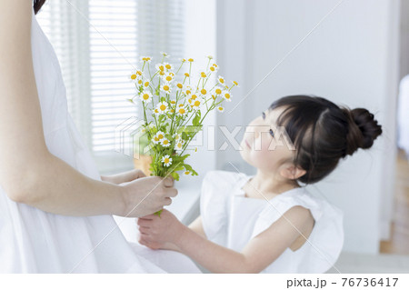 お花をプレゼントする女の子 76736417