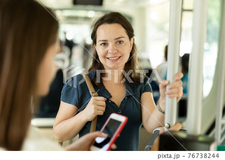 Positive woman traveling by city bus Positive woman traveling by city bus 76738244