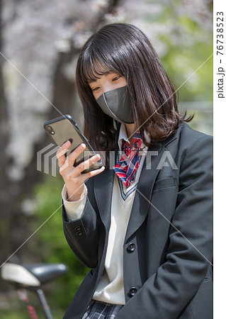 通学途中にスマホを見る女子高生 通学途中にスマホを見る女子高生 76738523
