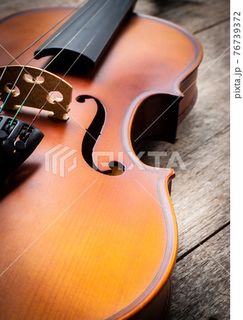 Closeup brown violin on wooden background. Art and music background. 76739372